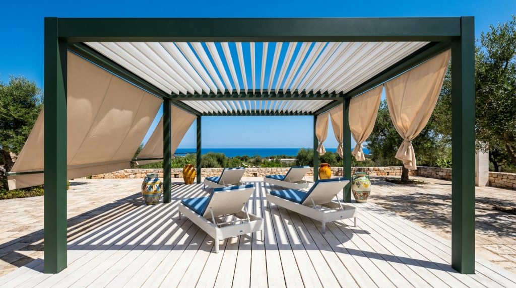 Pergola bioclimatica bioeclisse in alluminio verde con lamelle e tende beige su deck vista mare